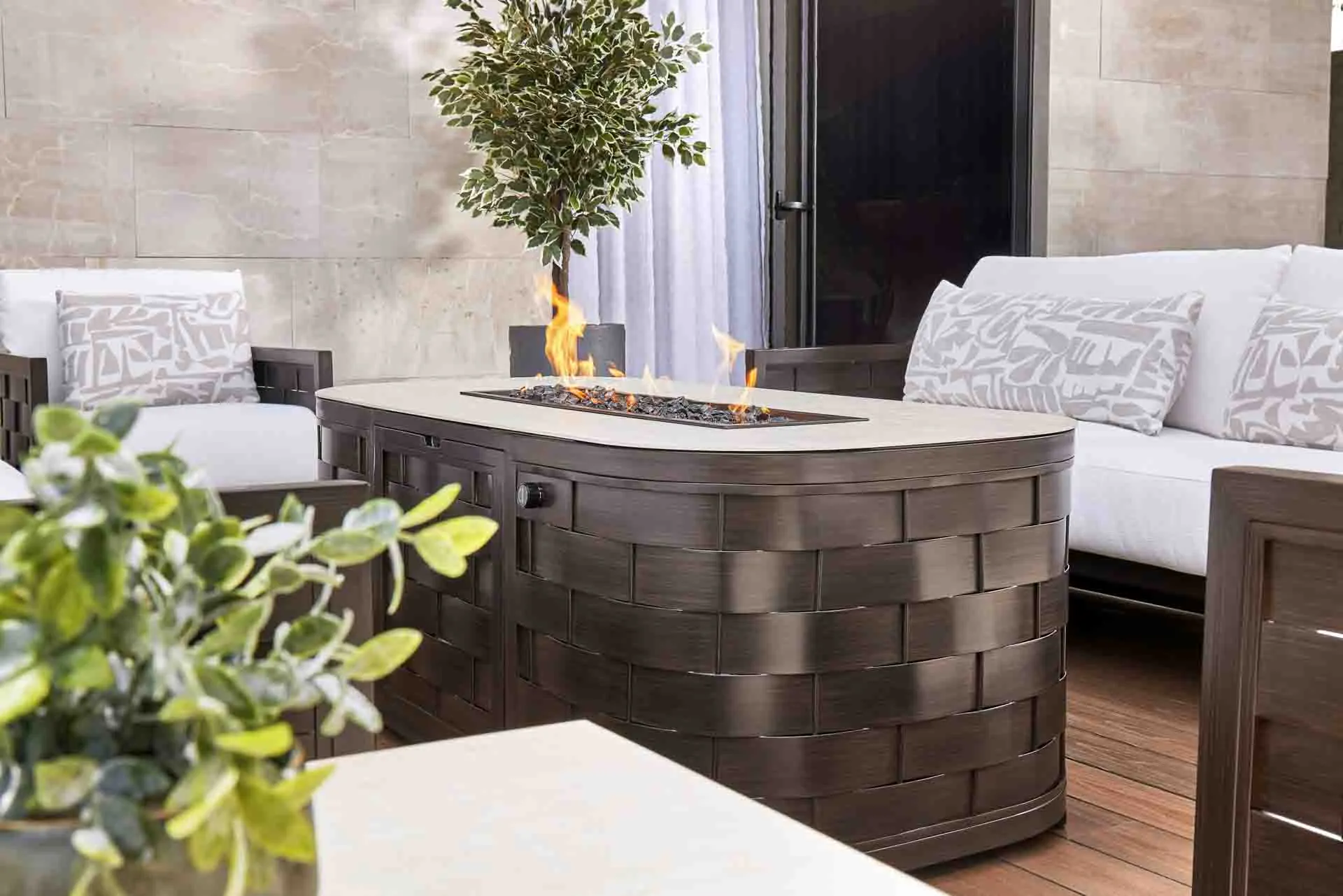 Outdoor ensemble of Castelle Fire Table in lounge seating area.