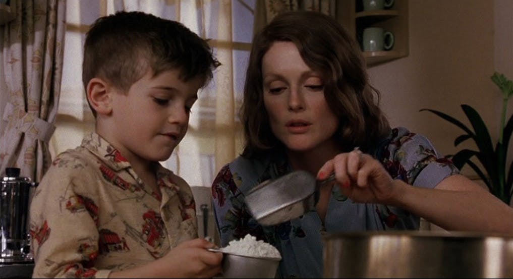 A woman and her young son cooking in a kitchen together.