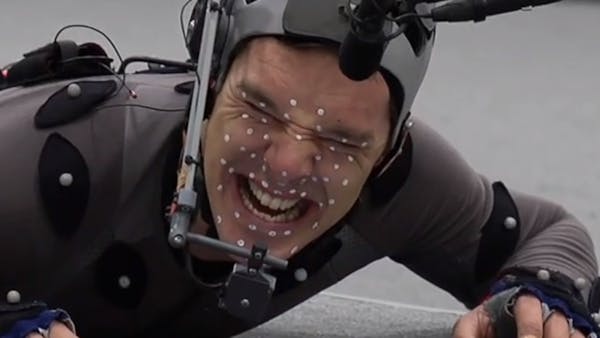Benedict Cumberpatch controrts his face while wearing motion capture suit