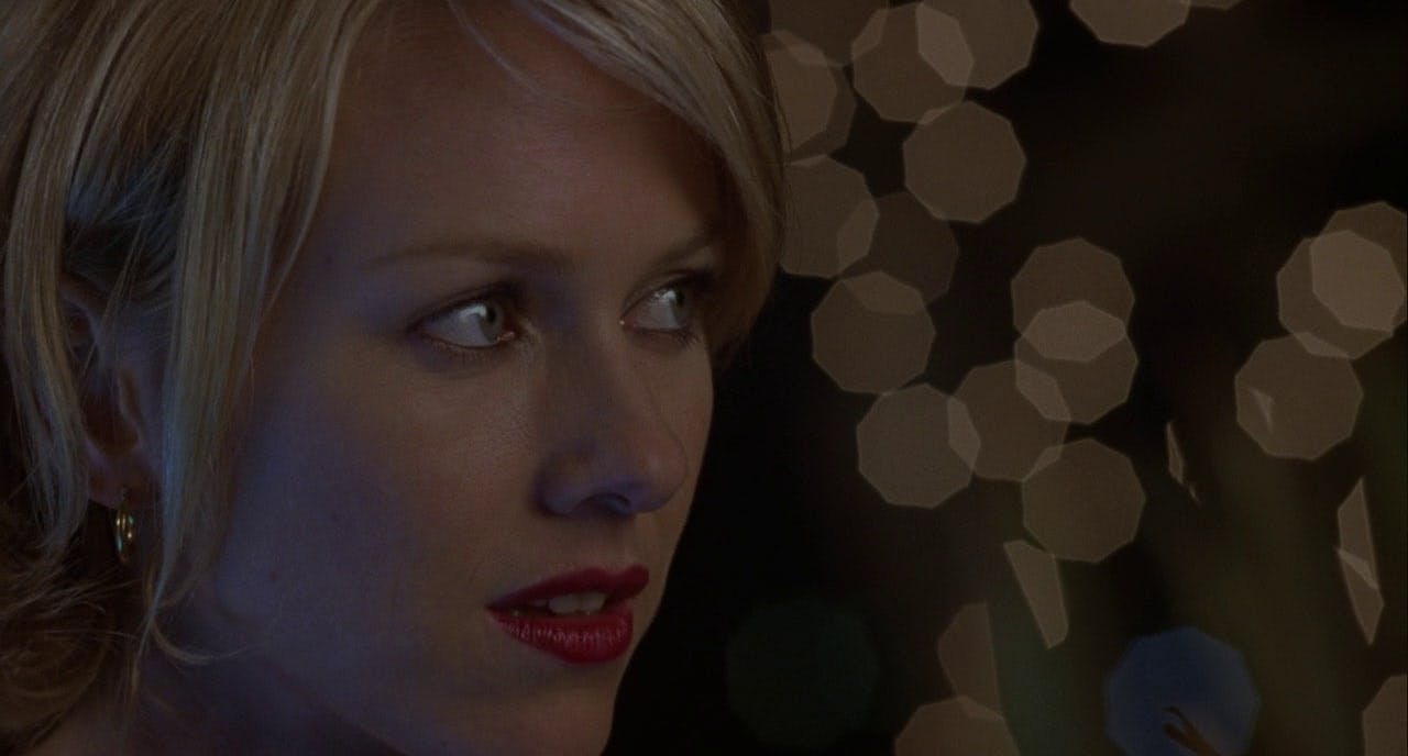 A woman with blonde hair and red lipstick gazes in a different direction.