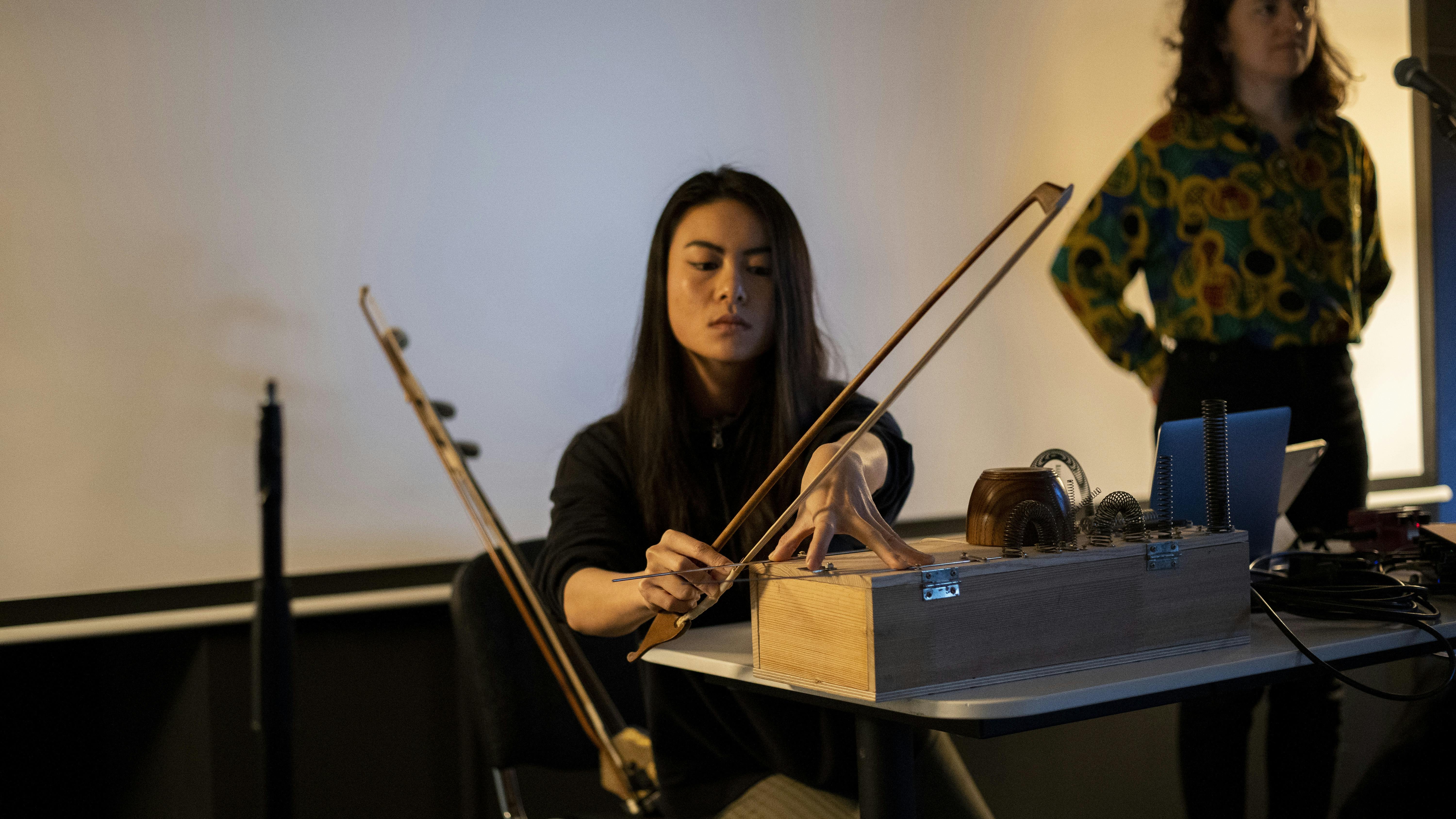music student plays homemade instrument with a bow