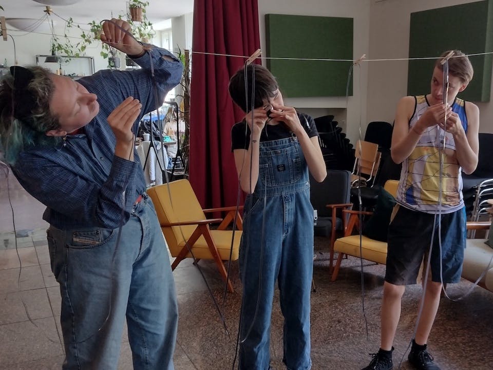 students inspect super8 film hanging on a rope