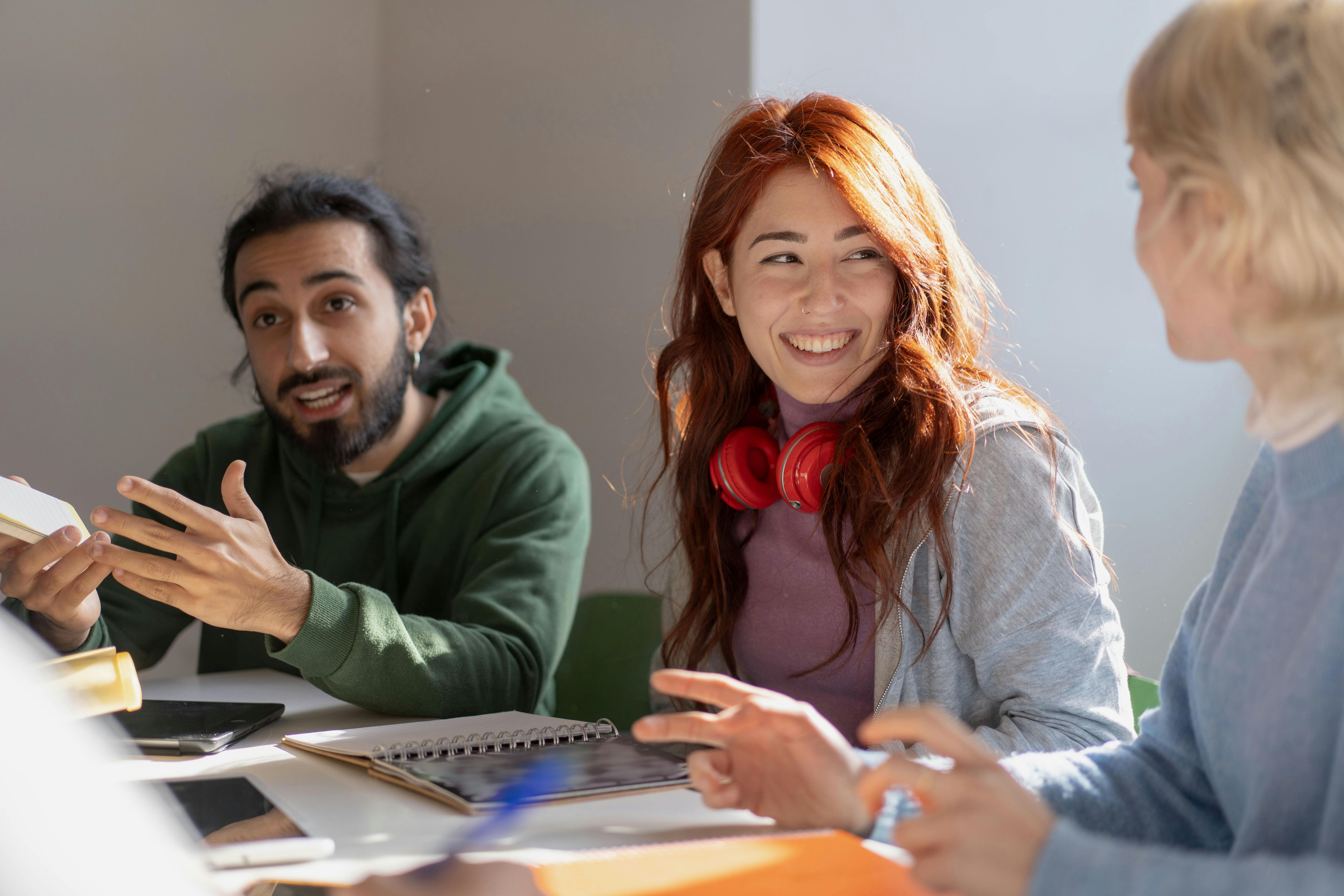 three students in discussion around a table
