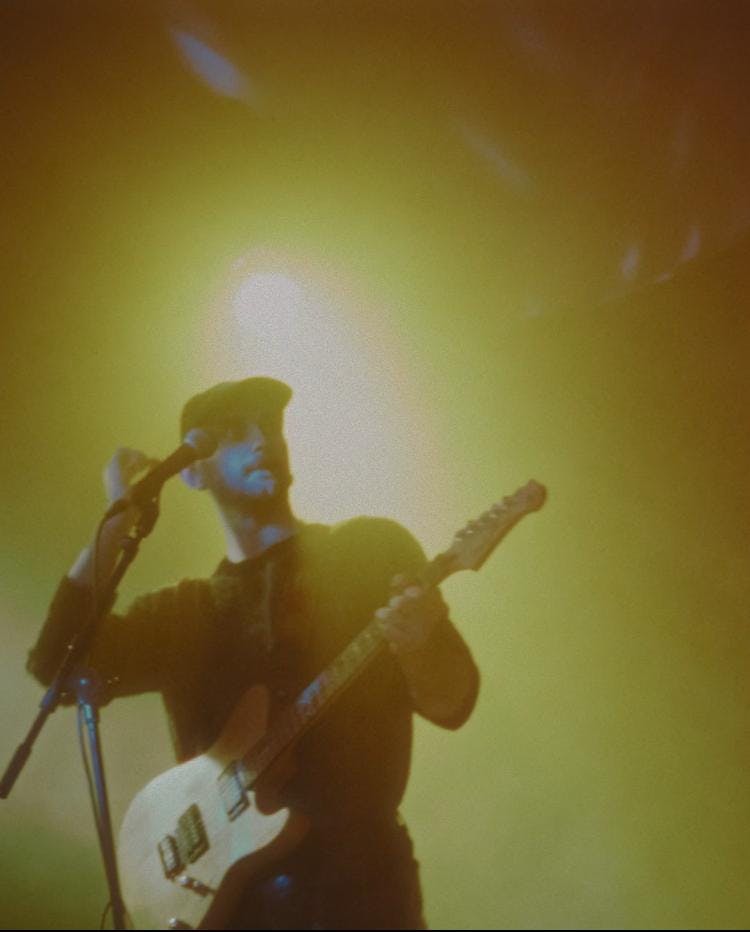 Silhouette of admissions partner Patrick Watt performing guitar onstage