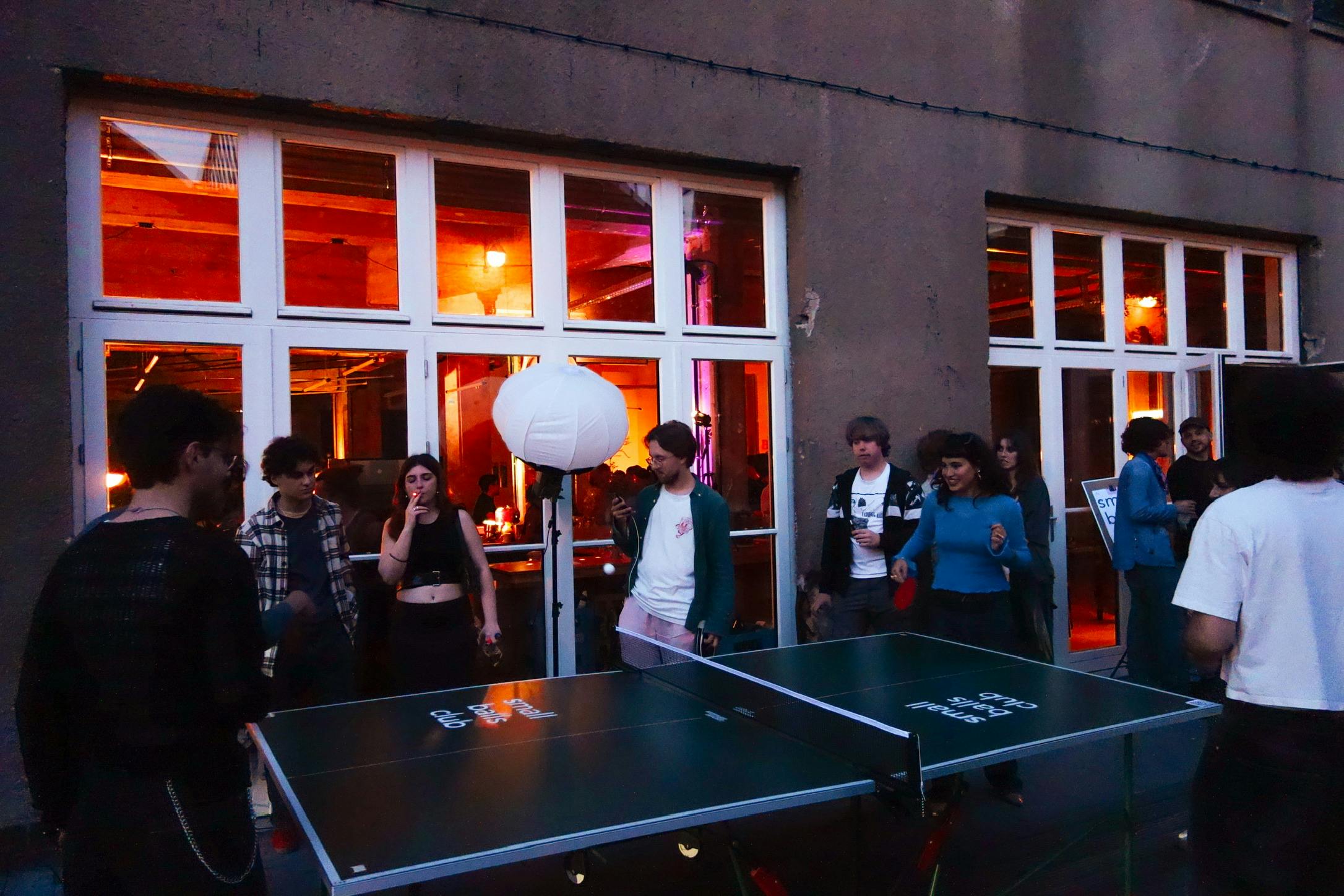 Catalyst students chatting and playing ping pong outside after The Catties ceremony