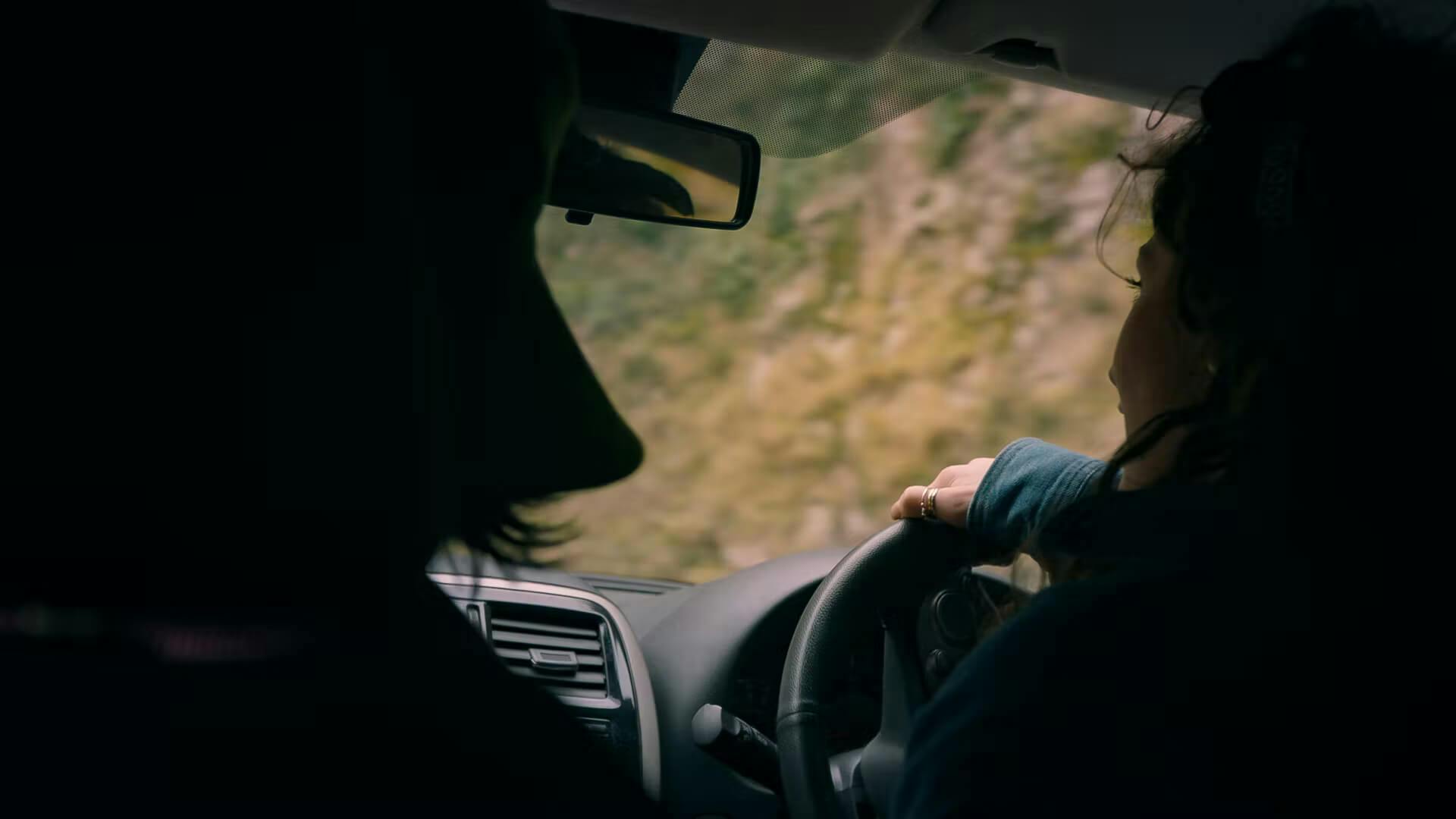 Woman driving a car on a mountain road