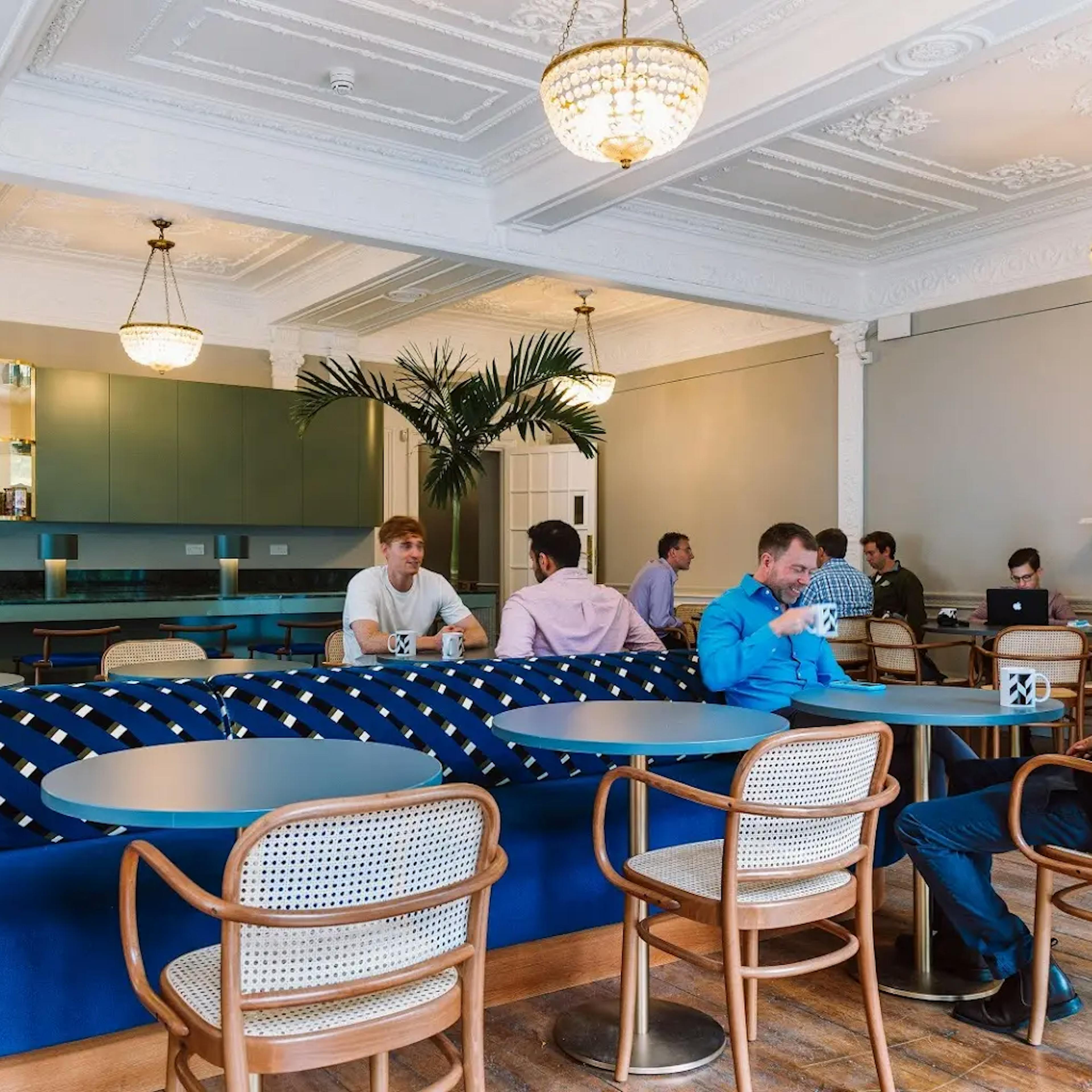 People chatting over coffee in an over breakout area