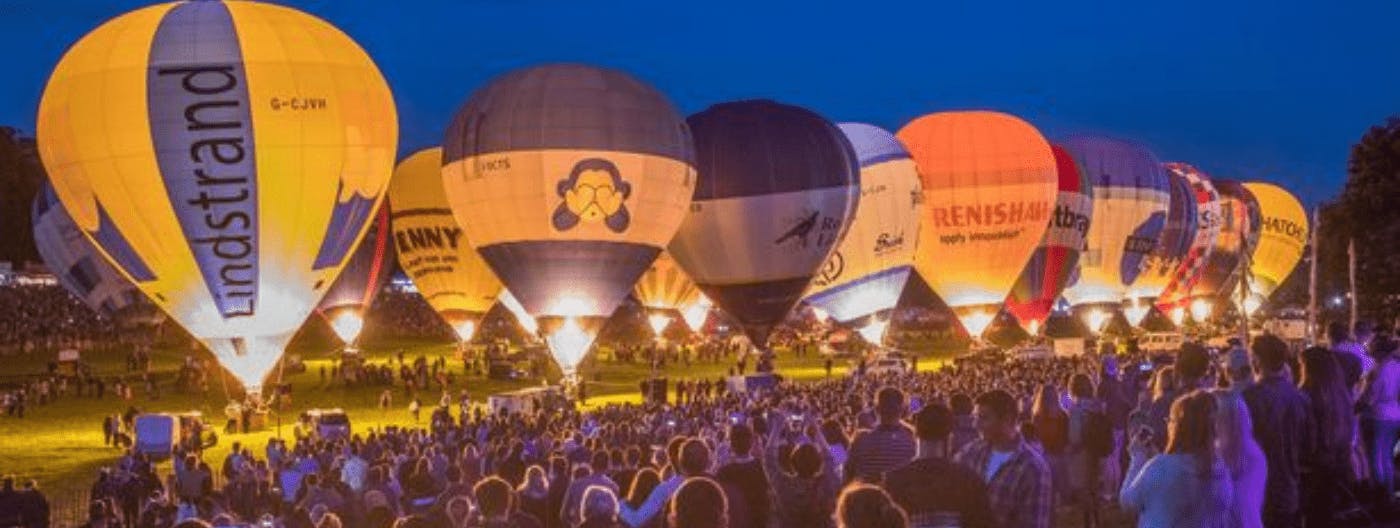 Nightglow show of hot air balloons lit up at the Bristol Balloon Fiesta