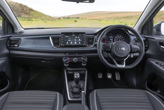 The interior of a Kia Rio with steering wheel and dashboard in shot