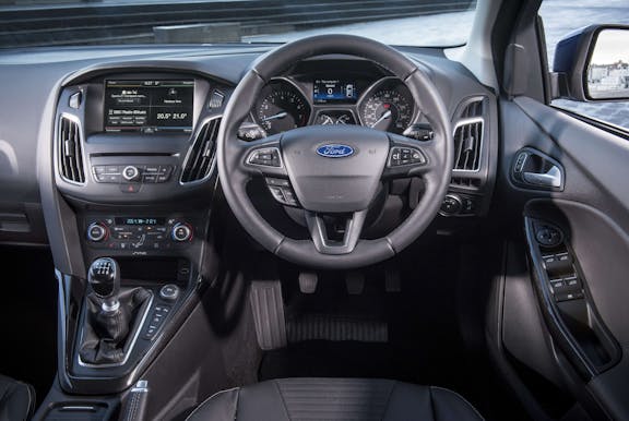 The interior of a Ford Focus with steering wheel and dashboard in shot
