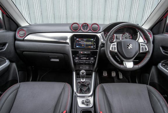 The interior of a Suzuki Vitara with steering wheel and dashboard in shot