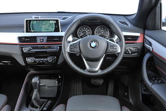 The interior of a BMW X1 with steering wheel and dashboard in shot