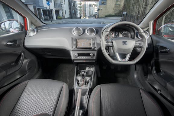 The interior of a Seat Ibiza with steering wheel and dashboard in shot