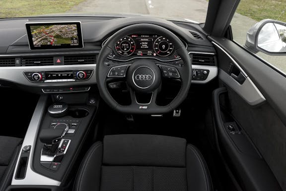 The interior of an Audi A5 with steering wheel and dashboard in shot