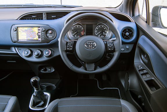 The interior of a Toyota Yaris with steering wheel and dashboard in shot