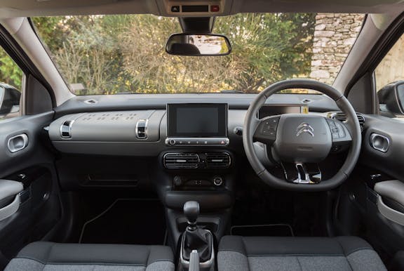 The interior of a Citroen C4 Cactus with steering wheel and dashboard in shot