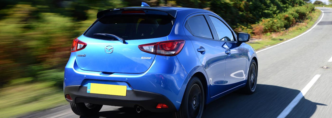 The rear exterior of a blue Mazda 2