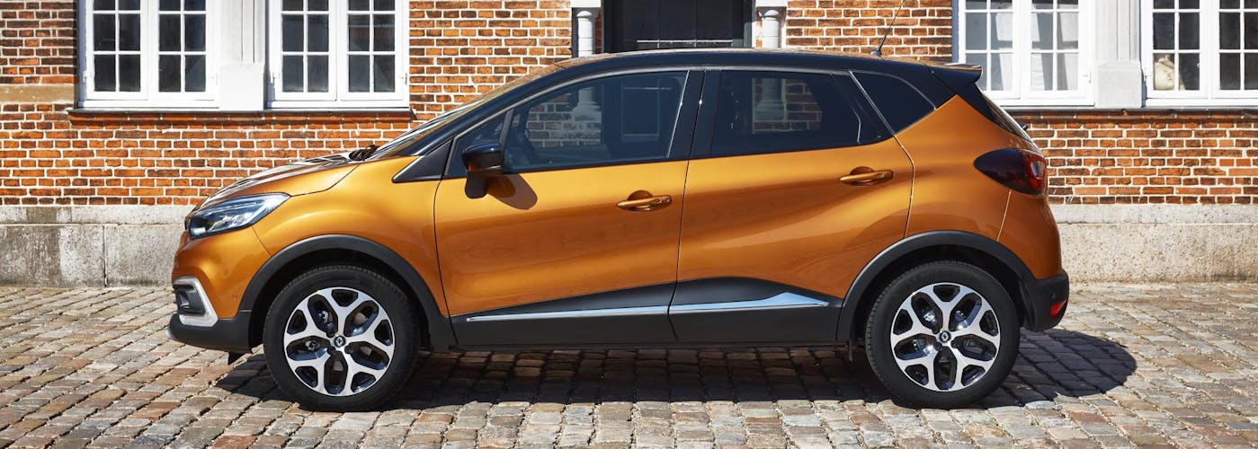 The side exterior of a yellow Renault Captur