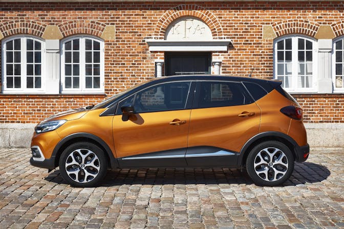 The side exterior of a yellow Renault Captur