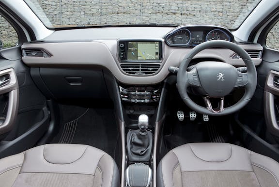 The interior of a Peugeot 2008 with steering wheel and dashboard in shot