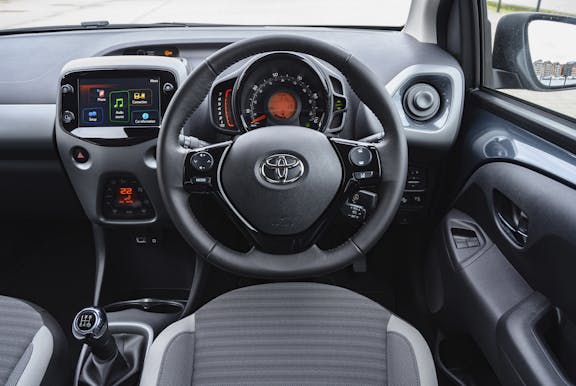 The interior of a Toyota Aygo with steering wheel and dashboard in shot