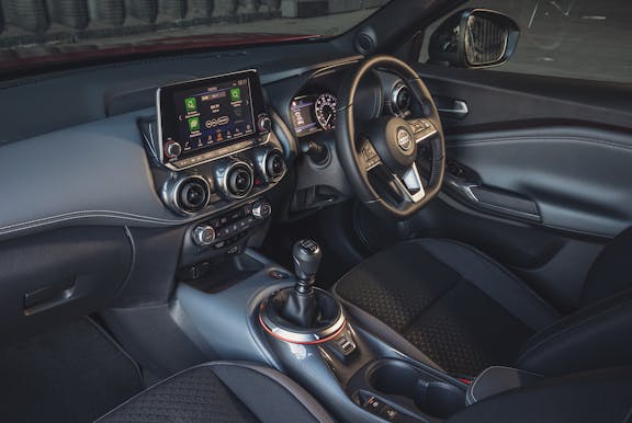 The interior of a Nissan Juke with steering wheel and dashboard in shot