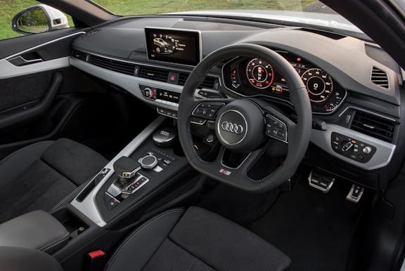 The interior of an Audi A4 with steering wheel and dashboard in shot