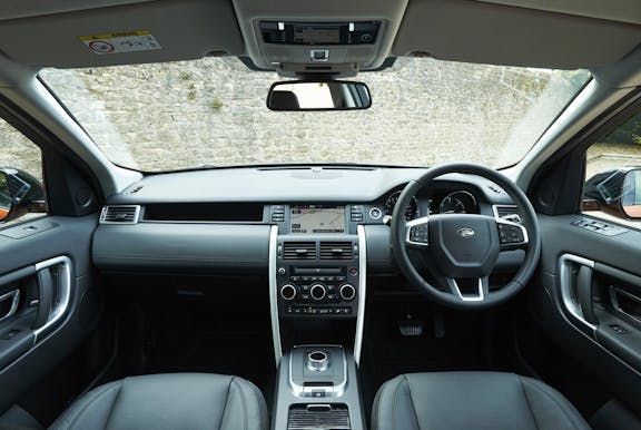 The interior of a Land Rover Discovery Sport with steering wheel and dashboard in shot