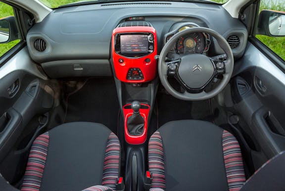 The interior of a Citroen C1 with steering wheel and dashboard in shot