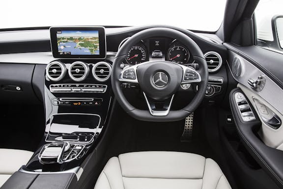 The interior of a Mercedes-Benz C-Class with steering wheel and dashboard in shot