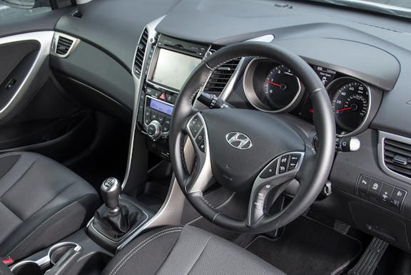 The interior of a Hyundai i30 with steering wheel and dashboard in shot