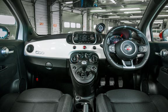 The interior with dashboard and wheel of an Abarth 595