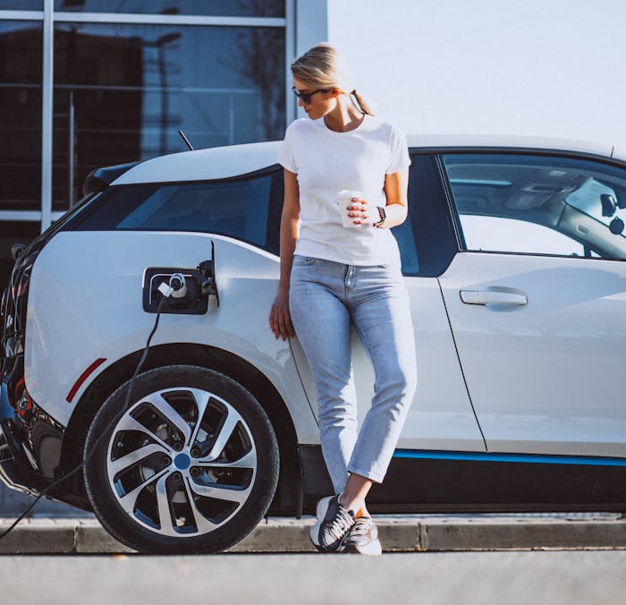 A woman charging her electric car