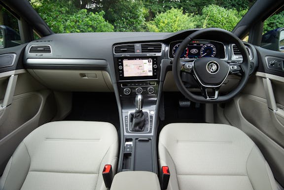 The interior of a Volkswagen Golf with steering wheel and dashboard in shot