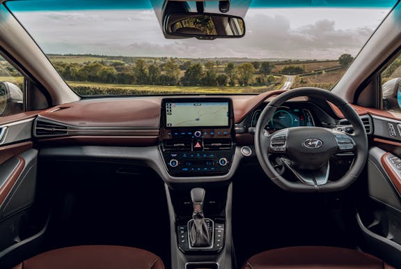 The interior of a Hyundai Ioniq with steering wheel and dashboard in shot