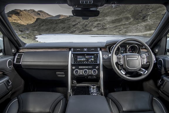 The interior of a Land Rover Discovery with steering wheel and dashboard in shot