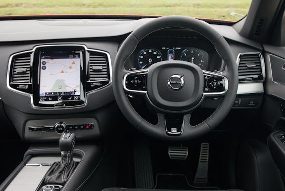 The interior of a Volvo XC90 with steering wheel and dashboard in shot
