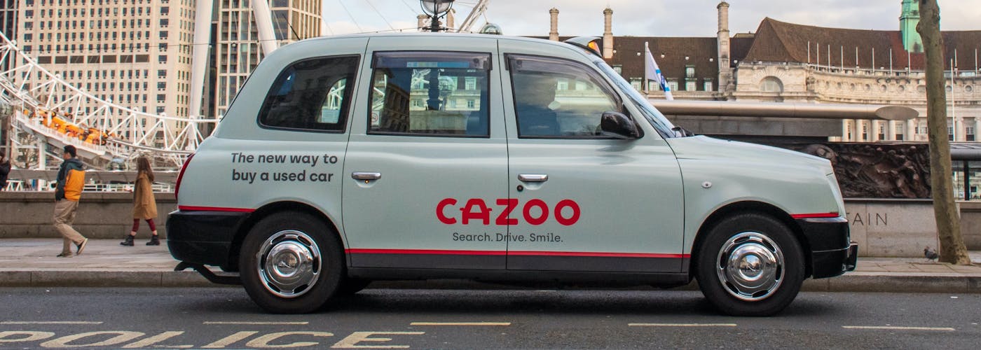 A London taxi with Cazoo advertising. The new way to a buy a used car. 