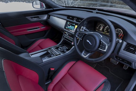 The interior of a Jaguar XF with steering wheel and dashboard in shot