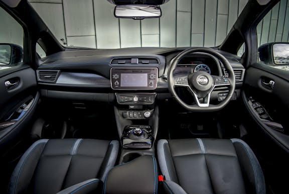 The interior of a Nissan Leaf with steering wheel and dashboard in shot