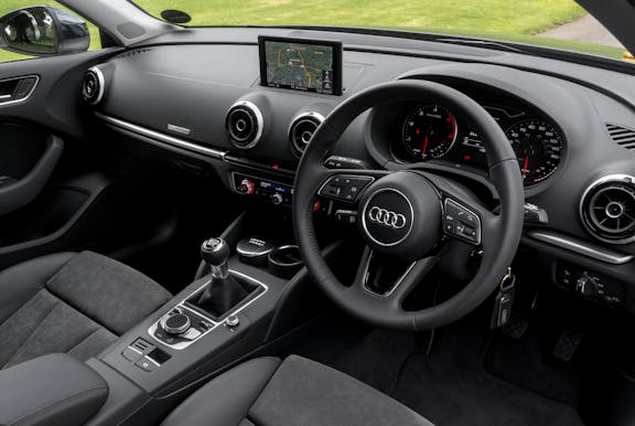 The interior of an Audi A3 with steering wheel and dashboard in shot