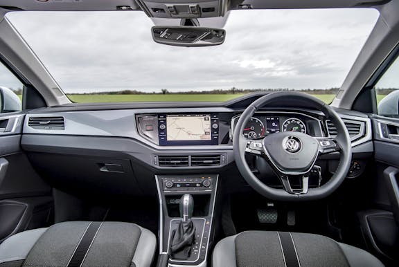The interior of a Volkswagen Polo with steering wheel and dashboard in shot