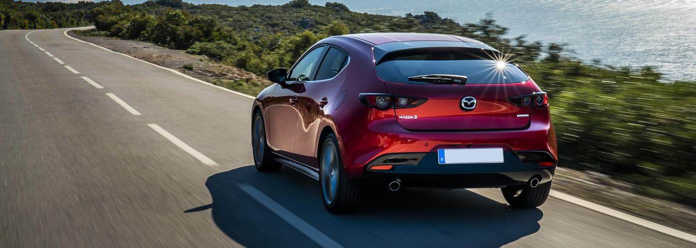 The rear exterior of a red Mazda 3