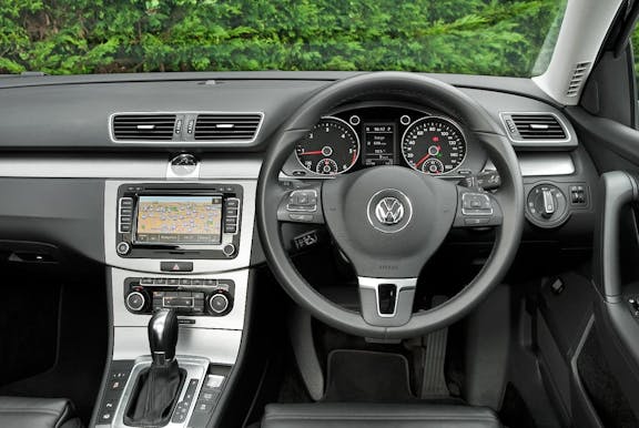 The interior of a Volkswagen Passatwith steering wheel and dashboard in shot