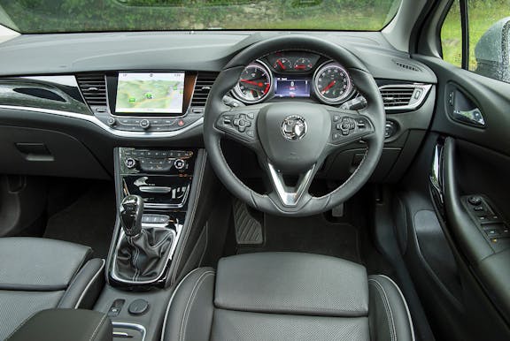 The interior of a Vauxhall Astra with steering wheel and dashboard in shot