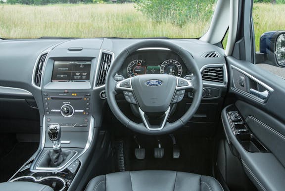 The interior of a Ford S-Max with steering wheel and dashboard in shot