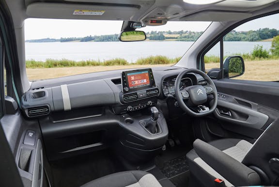 The interior of a Citroen Berlingo with steering wheel and dashboard in shot