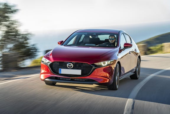 The front exterior of a red Mazda 3