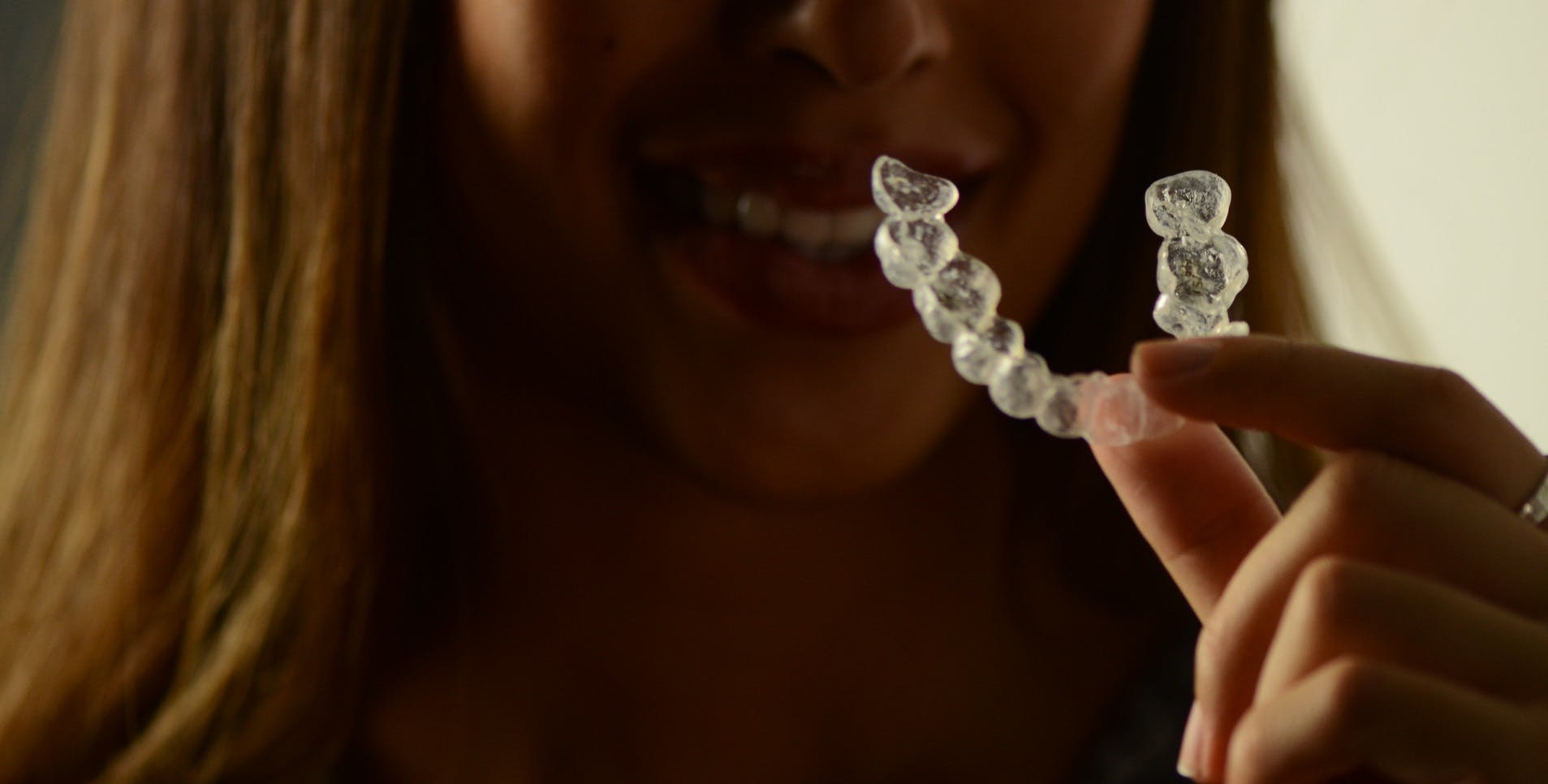 Intan holding Invisalign aligner. 