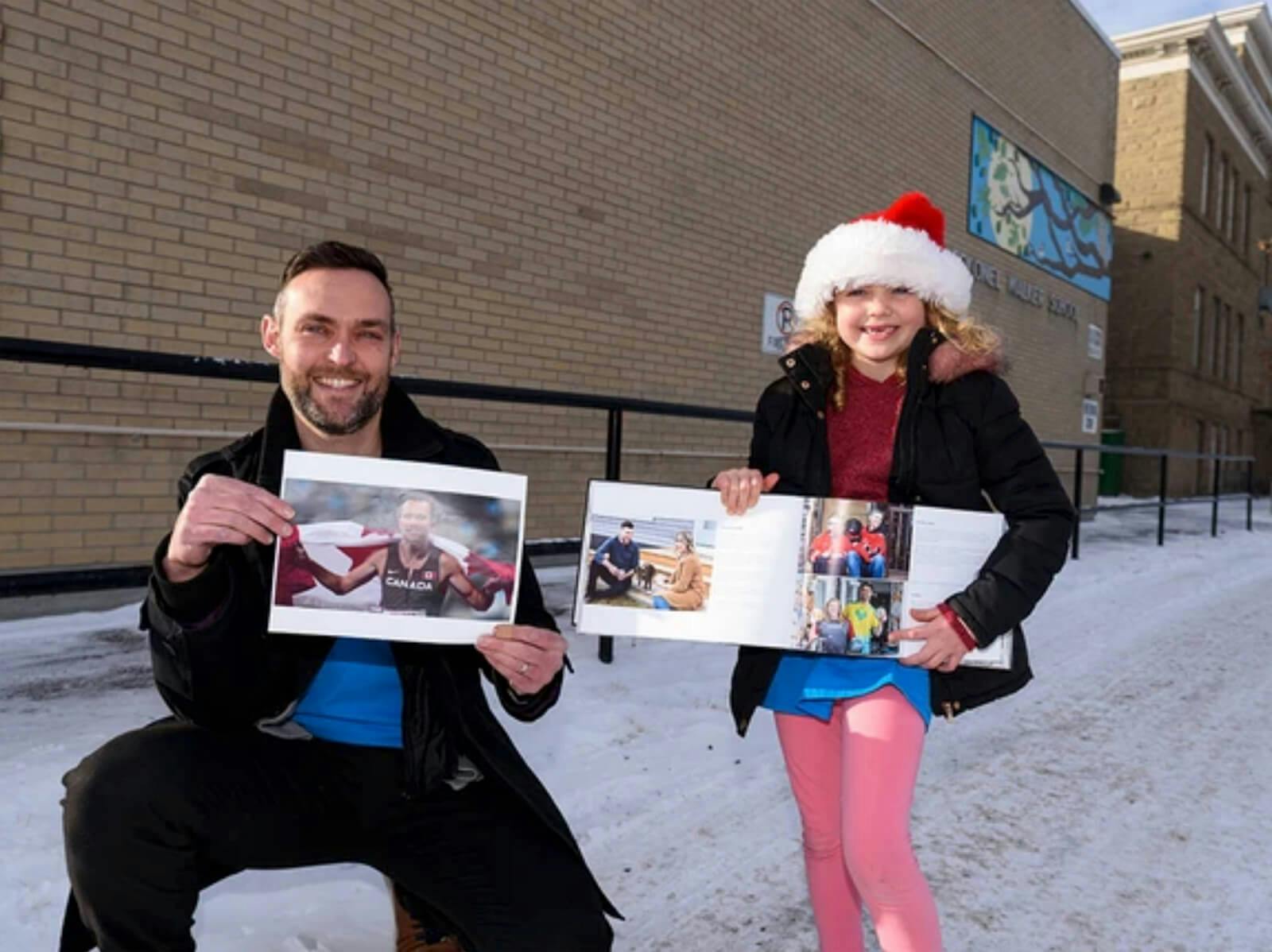 Grade 3 teacher Geoff Kearney holding a photo of Canadian Paralympian Nate Riech, and student Josephine Brown